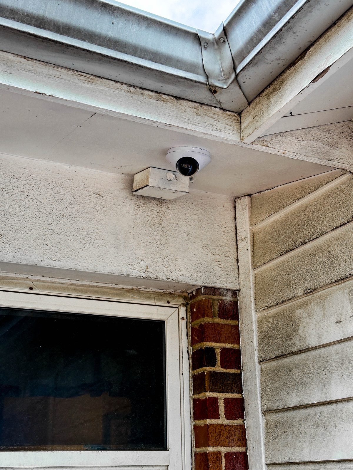 Exterior camera under the eave of a brick building
