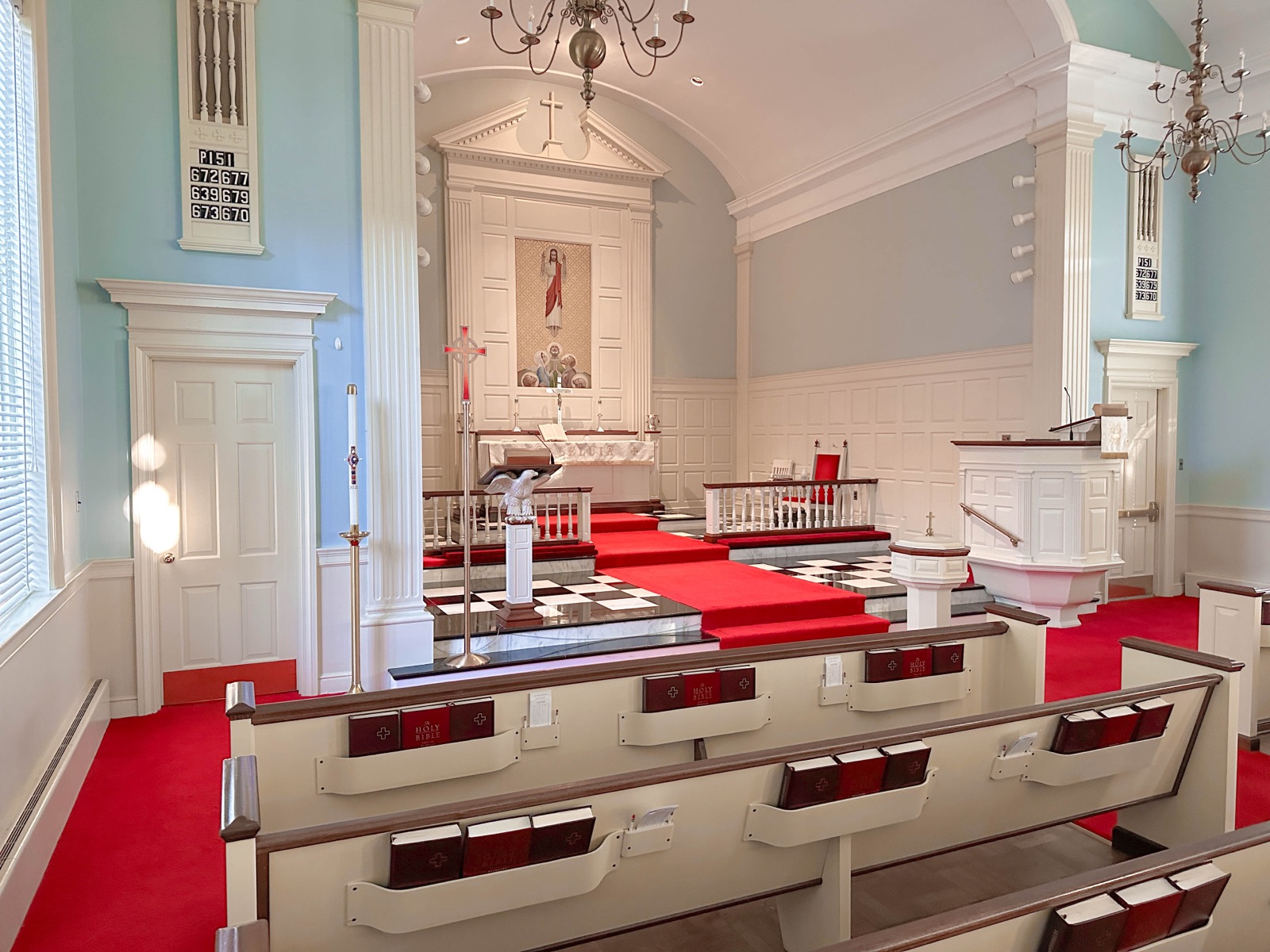 Historic sanctuary with white pews and red carpet