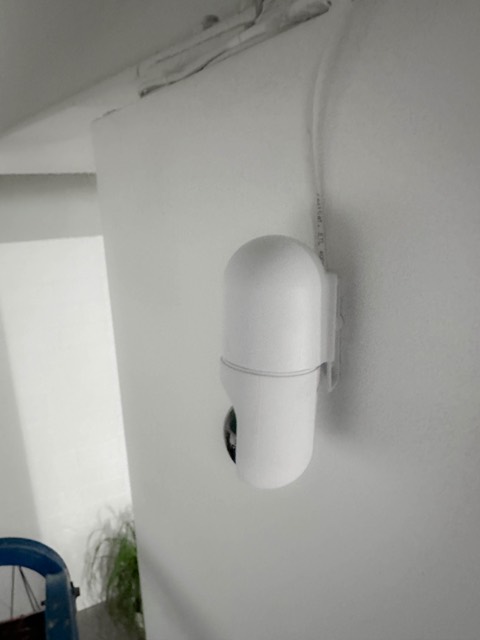 Compact security camera on a white wall