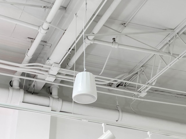 Pendant speaker and conduit on the open ceiling