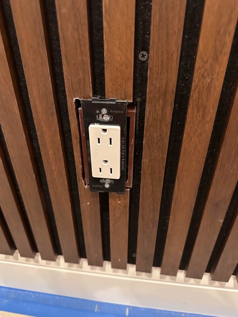 Outlet built flush into the slat wall
