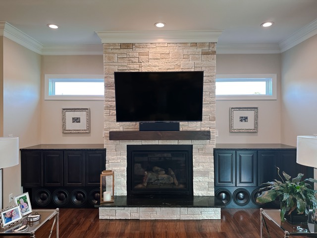 TV mounted above a stone fireplace with built-in cabinets