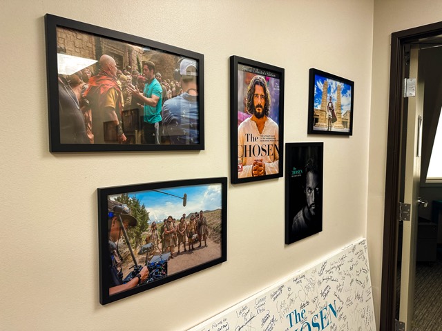 Framed production stills in the office hallway