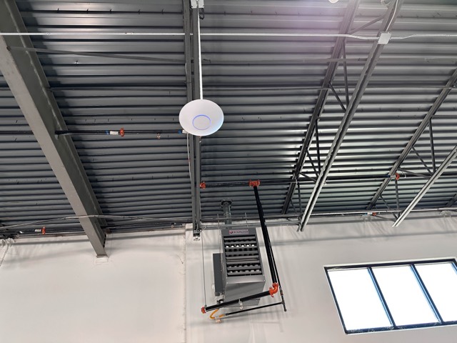 Ceiling access point beside a skylight in the warehouse