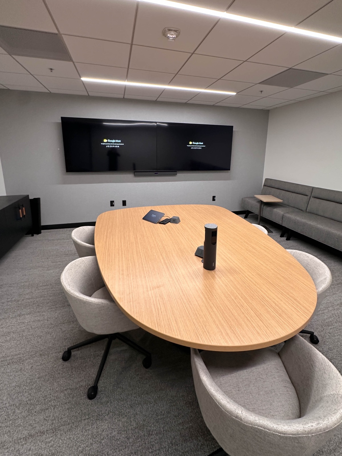 Boardroom with dual displays and oval table